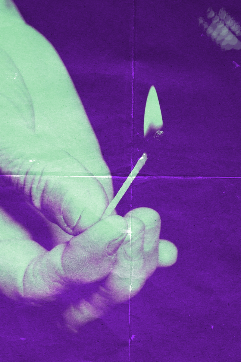 Close-up of a person’s hand holding a lit match